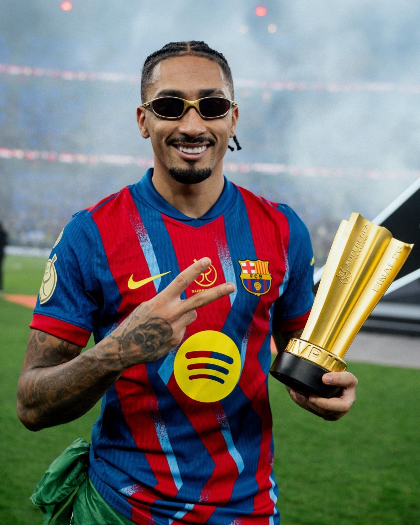 Raphinha đeo kính cầm cúp MVP Barcelona, ăn mừng chiến thắng.